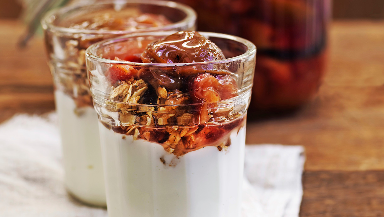 Henkogte blommer serveret med skyr og granola