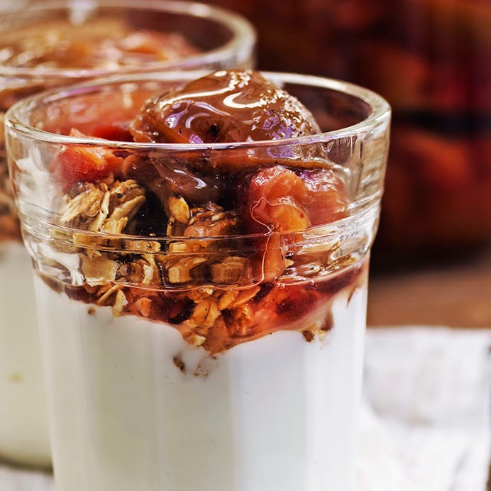 Henkogte blommer serveret med skyr og granola