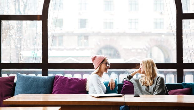To kvinder taler sammen på café