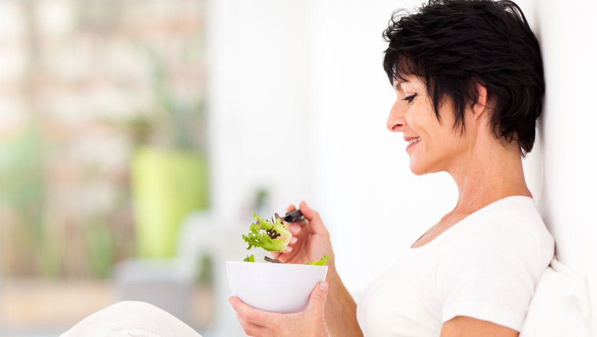 Moden kvinde spiser salat