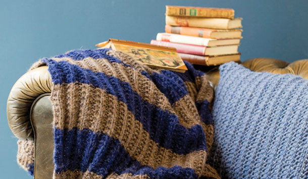 Strikkeopskrift plaid: Plaid liggende på sofa