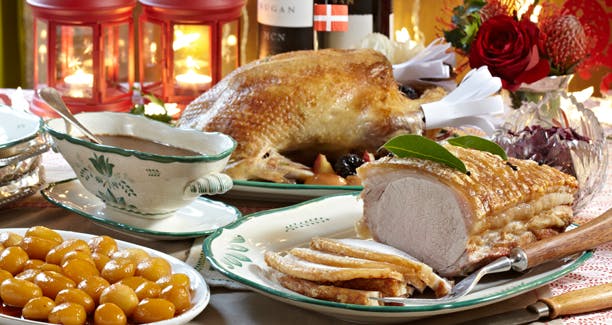 Julemad: And, flæskesteg, brunede kartofler og sovs på bord 
