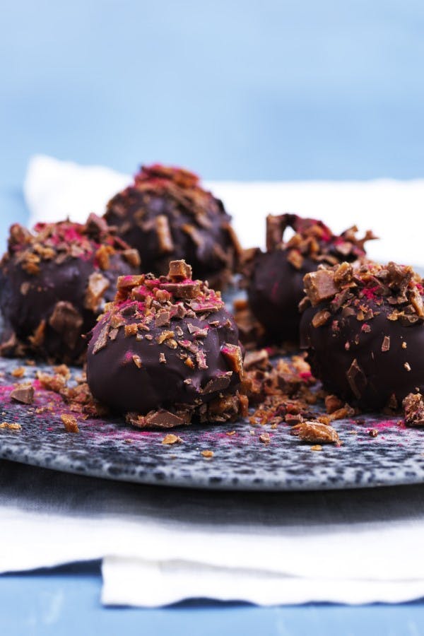 Romkugler med knust daim og frysetørret hindbær på toppen