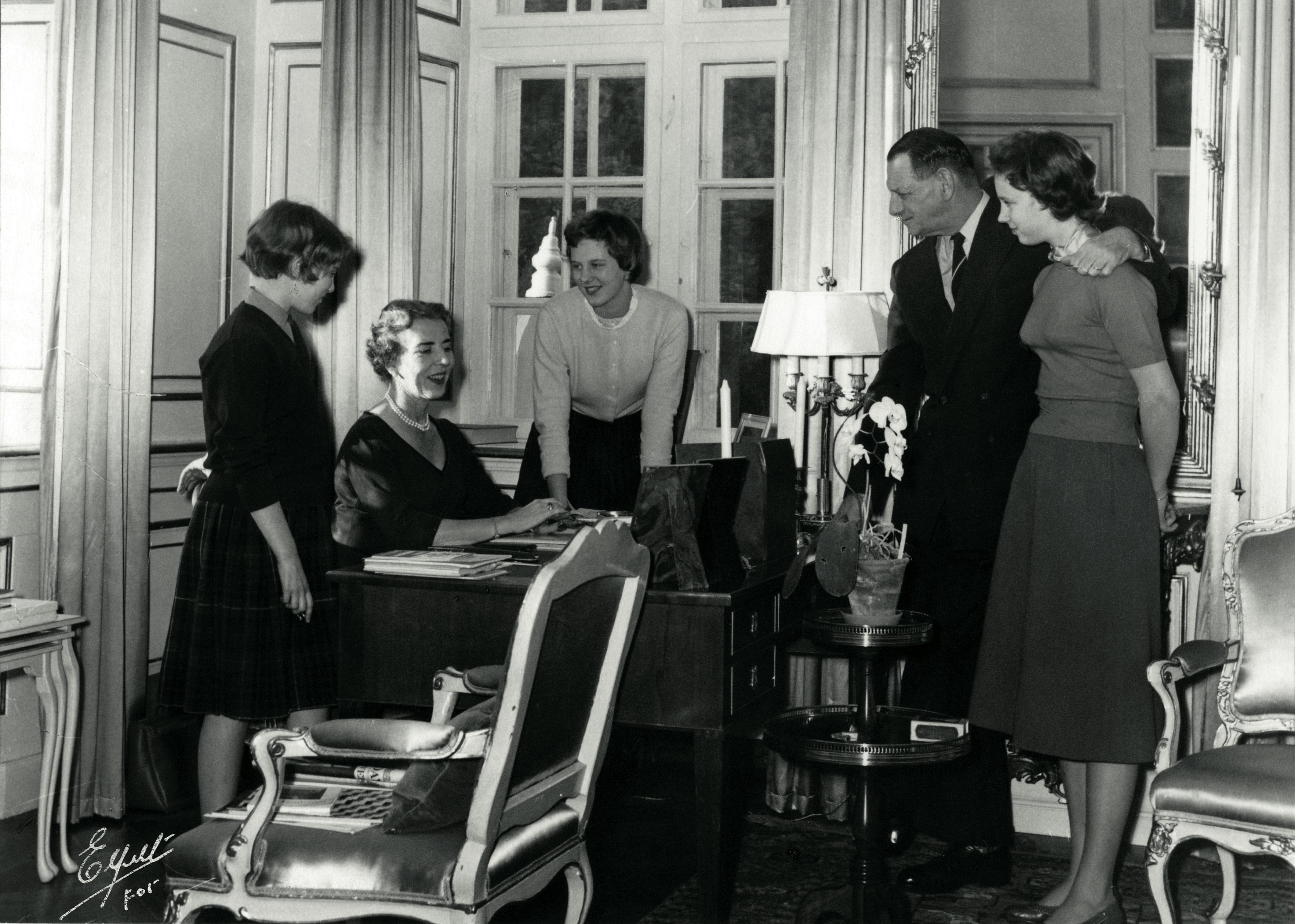Et kig ind i dronning Ingrids arbejdsværelse med kongefamilien samlet rundt om skrivebordet, fra venstre Anne-Marie, Ingrid, Margrethe, Frederik og Benedikte